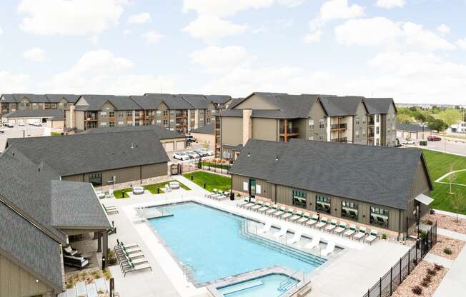 an aerial view of a swimming pool with apartments in the background