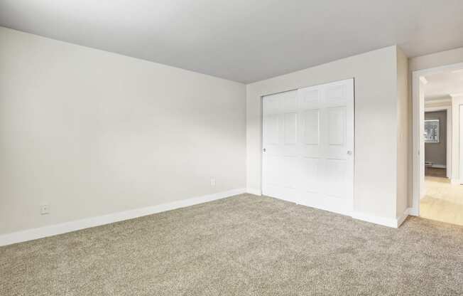 an empty living room with a white door and carpet at 2000 Lake Washington Apartments, Renton, WA, 98056