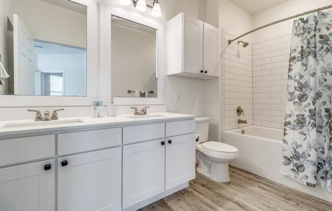 a bathroom with white cabinets and a shower and a toilet