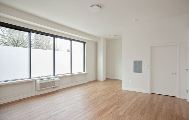 a living room with a large window and wood floors