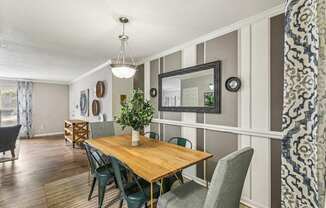 A dining room with a wooden table and chairs.