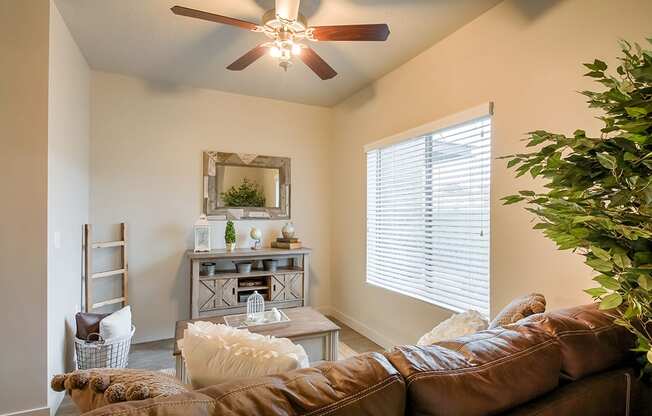 a living room with a ceiling fan and a large window