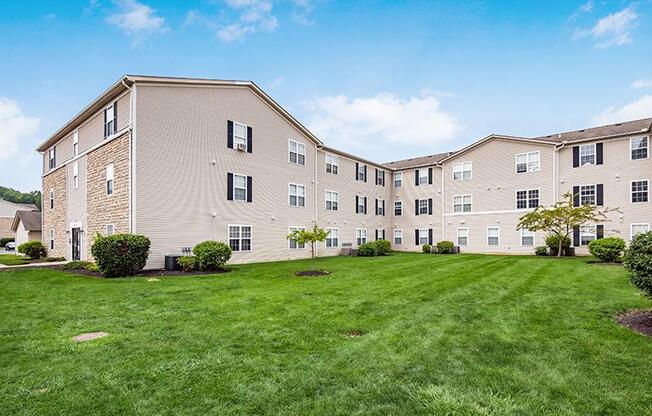 A large apartment complex with a green lawn in front.
