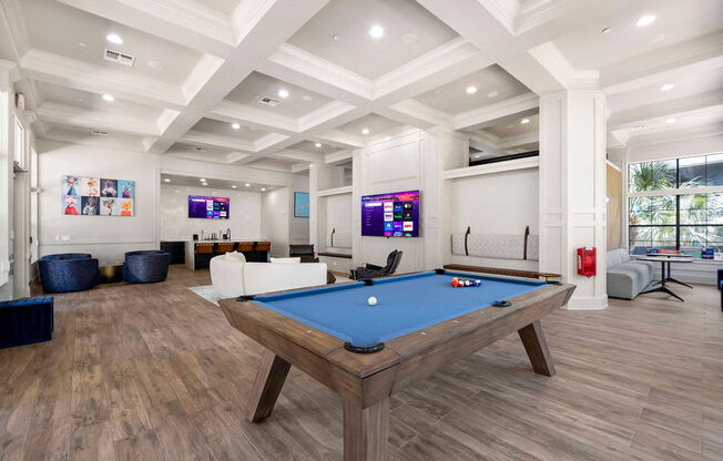 a games room with a pool table in the middle