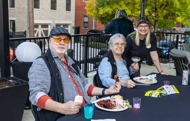 a man and two women sitting at a table eating food