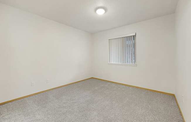 a bedroom with white walls and carpet