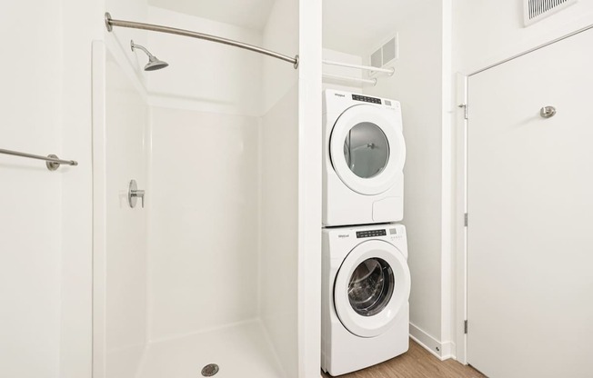 A white bathroom with a washer and dryer in it.
