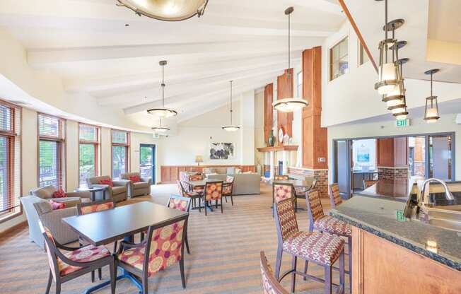 a large lobby with tables and chairs and a kitchen