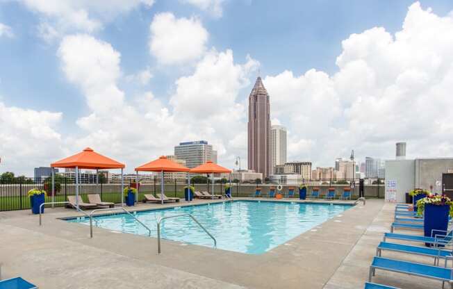 a swimming pool on the roof of a building with the city in the background