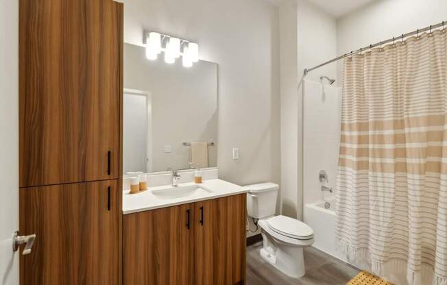 A bathroom with a toilet, sink, and shower.