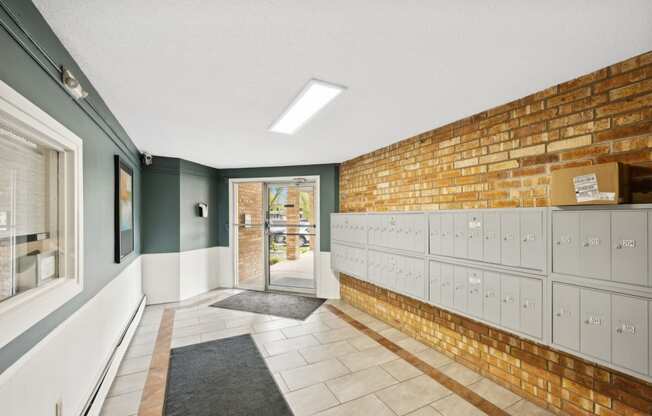 the locker room at the clubhouse has a brick wall and white lockers