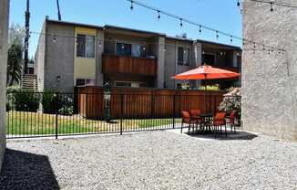 View from inside pool area facing exterior of buildings featuring private patio/balconies, and seating areas within pool