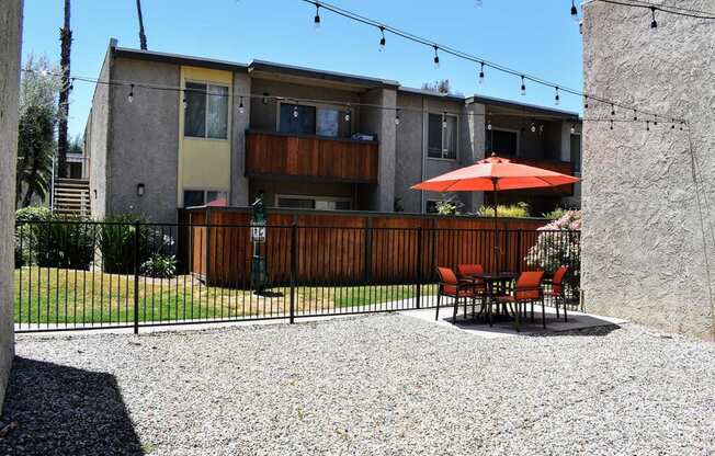 View from inside pool area facing exterior of buildings featuring private patio/balconies, and seating areas within pool