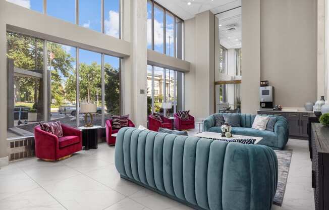 a living room filled with furniture and large windows