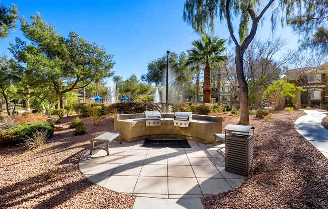 A sunny day at the park with a fountain and benches.
