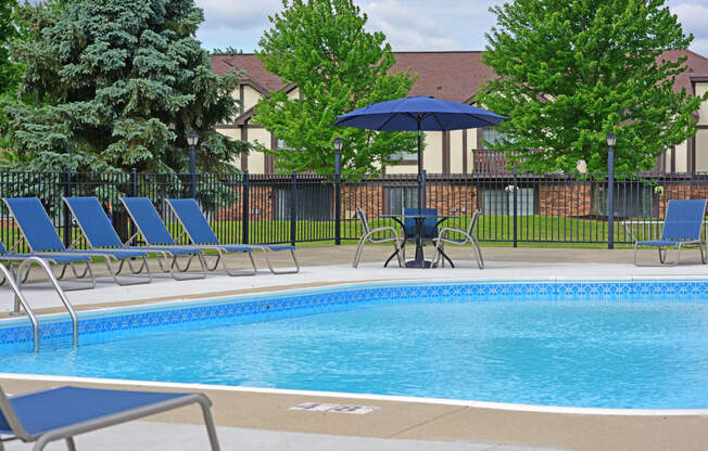 our apartments have a swimming pool with chairs and umbrellas