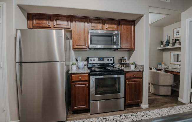 A modern kitchen with stainless steel appliances and wooden cabinets.