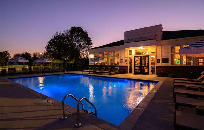 a swimming pool in front of a house at night