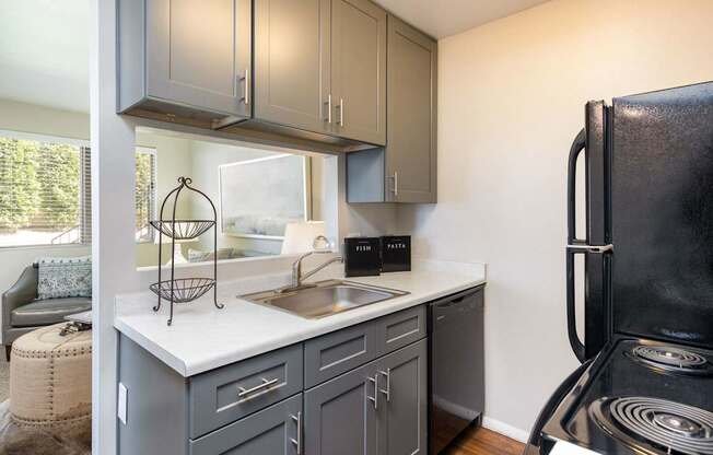 a kitchen with a sink and refrigerator and a window