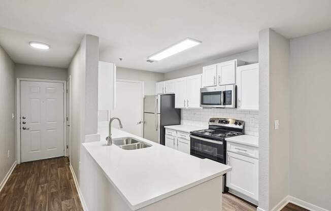 A kitchen with white cabinets and a white island.