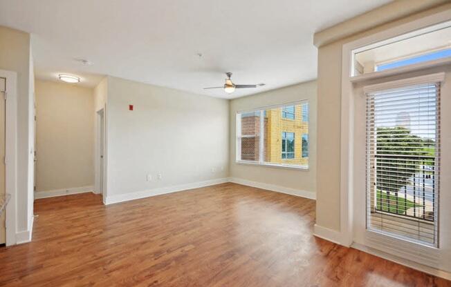 an empty living room with a large window and wood flooring at Link Apartments® Brookstown, Winston Salem, NC, 27101