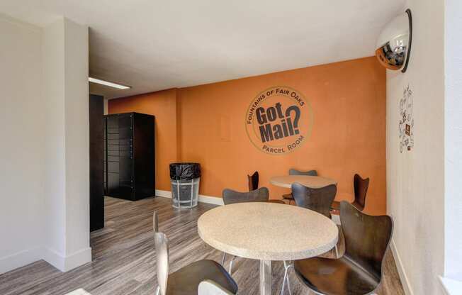 Parcel Room with Hardwood Inspired Floor, Short Round Tables, Chairs, Orange Wall with 