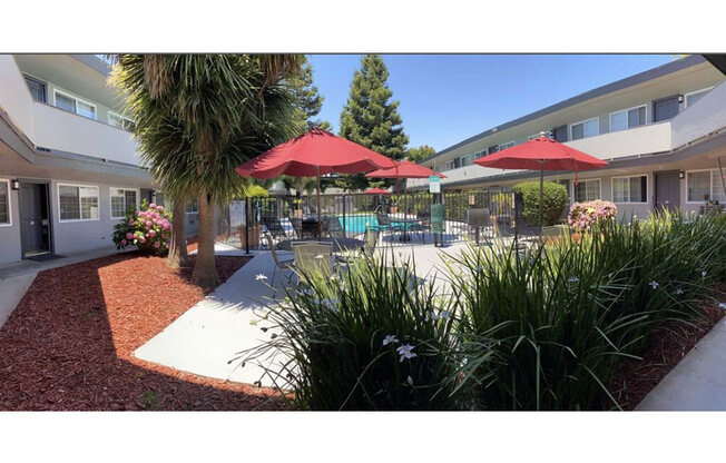 a patio with umbrellas and chairs in front of a building