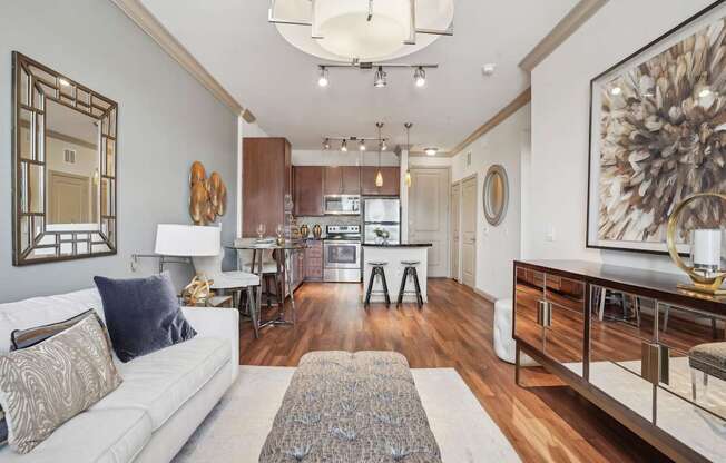 A modern living room with a white couch and a large painting on the wall.