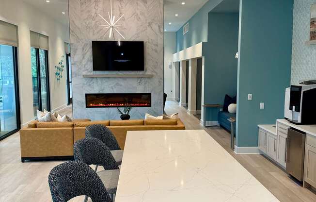 A modern kitchen with a white marble island and a television mounted above it.