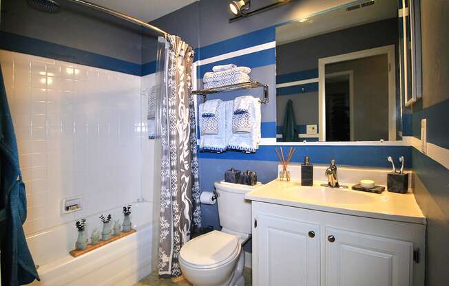 a blue and white bathroom with a shower toilet and sink at Village Club of Rochester Hills, Shelby Township, 48317