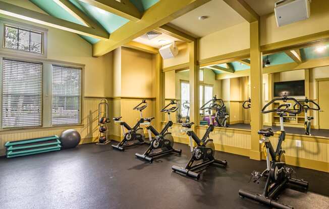 a gym with exercise bikes and weights on the floor