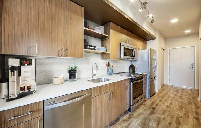 a kitchen with wooden cabinets and stainless steel appliances at The Hayes on Stone Way, Washington
