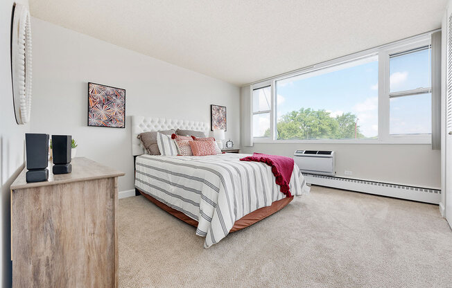 a bedroom with a bed and a large window