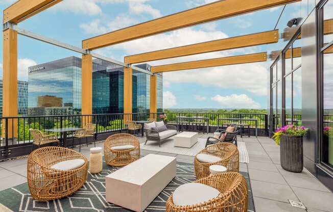 a rooftop patio with chairs and tables and a view of the city