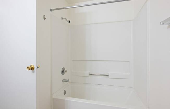 a white bathroom with a shower and a tub