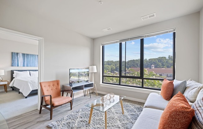 a living room with a large window and a couch and chair