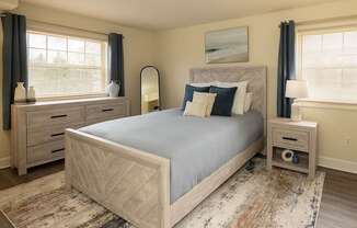 A bedroom with a large bed, nightstands, and a rug.