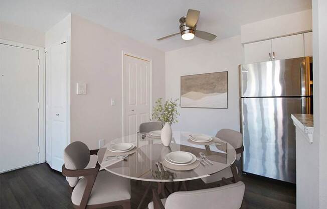 A modern dining room with a glass table and chairs.