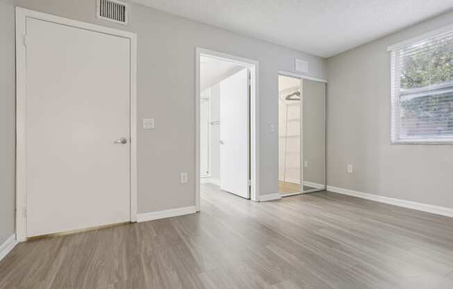 the living room of an apartment with white walls and wood floors at Pembroke Pines Landings, Pembroke Pines, FL 33025