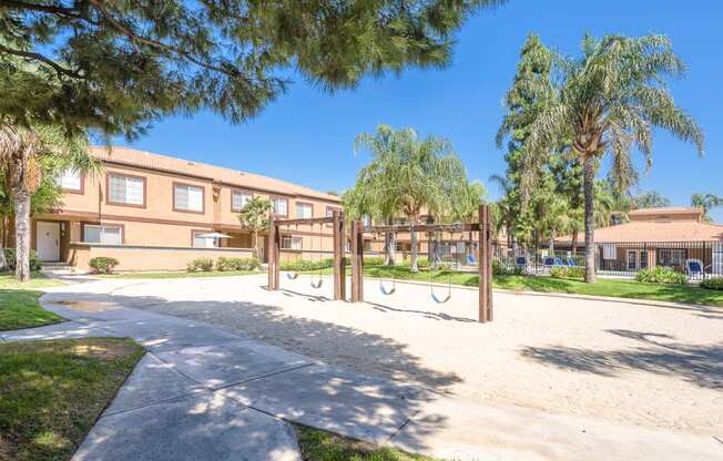 a playground in front of a building with palm trees