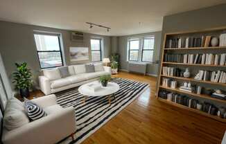 a living room with white furniture and a striped rug