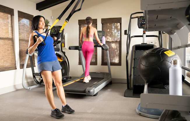 Two women exercising in a gym.