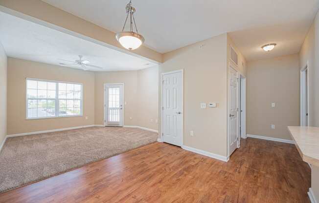 an empty living room and dining room with hard wood flooring