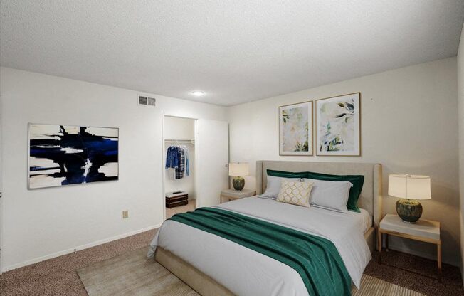 a bedroom with a bed and paintings on the wall