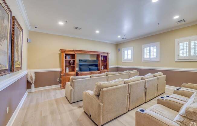 A living room with a row of couches and a bookcase.