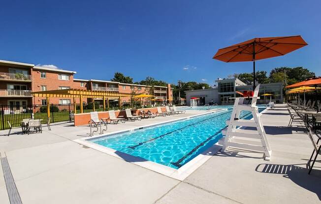 A swimming pool with a ladder and sunshades.