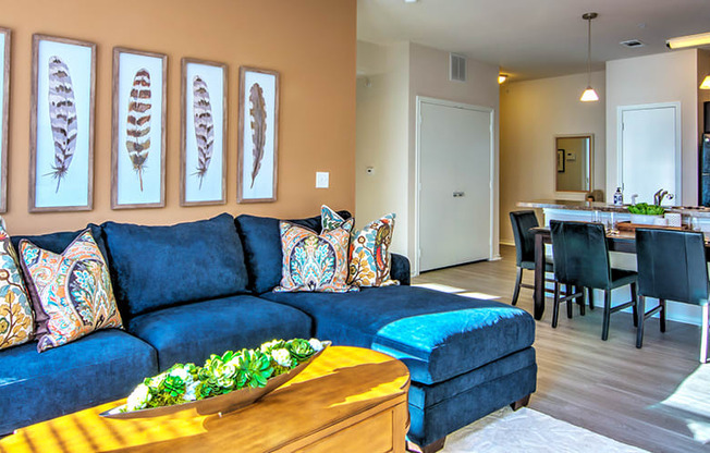 a living room with a blue couch and a wooden coffee table at Villa Espada Apartments, San Antonio, Texas