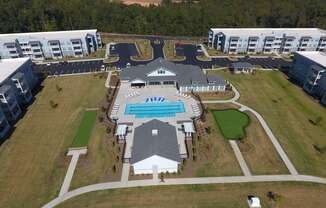 an aerial view of a resort with buildings and a pool