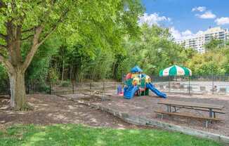 A playground with a slide, swings, and a picnic table.