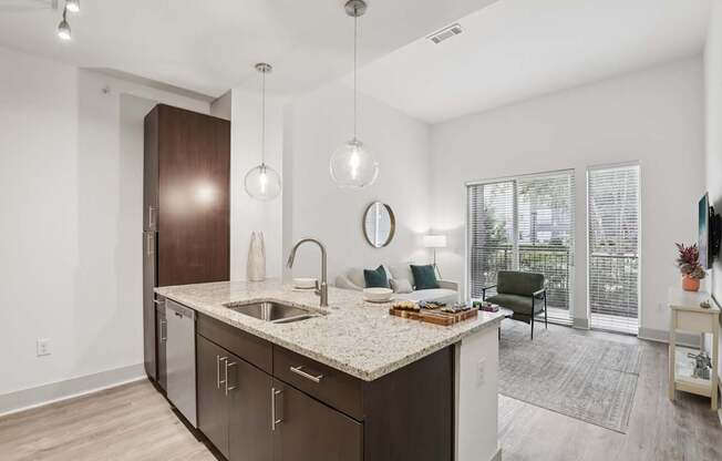 A kitchen with a sink, a counter, and a chair.